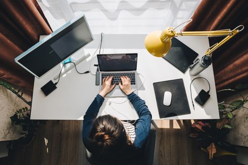 Foto: Frau sitzt im Homeoffice beim Schreibtisch und arbeitet am Laptop